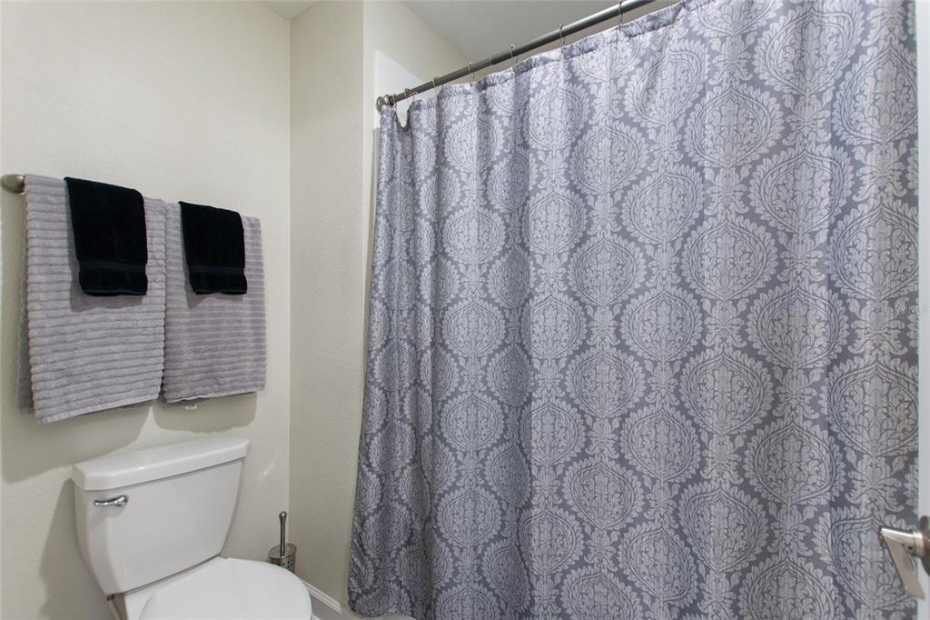 8811 Bally Neal Loop Davenport, FL 33896 - Photo 42 of 82 a bathroom with a toilet and a shower curtain