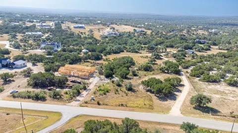an aerial view of residential houses with outdoor space and trees