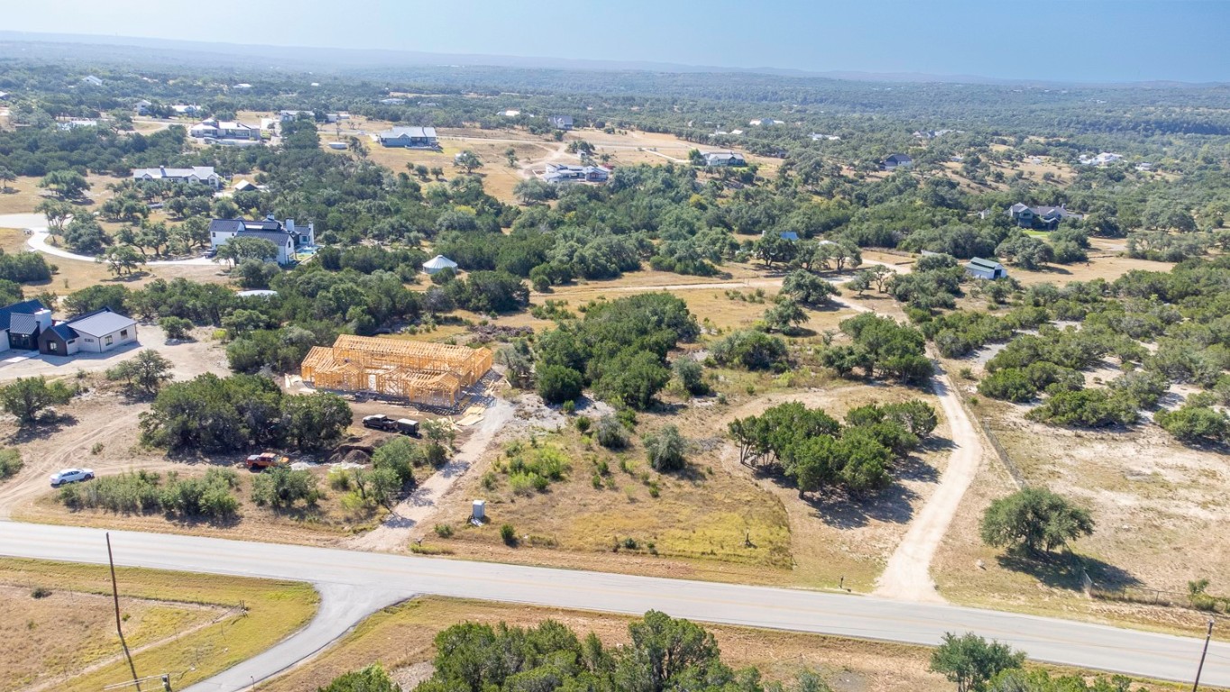 an aerial view of residential houses with outdoor space and trees