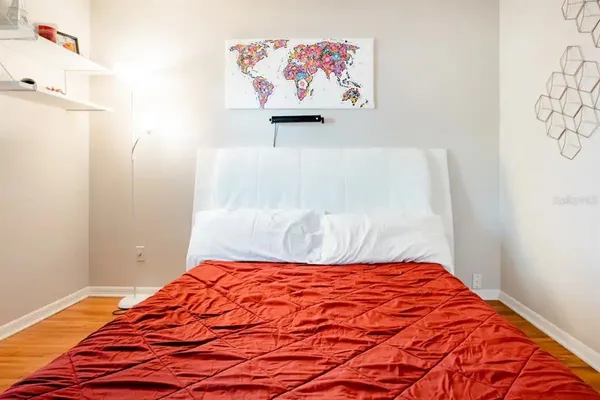 a bedroom with a bed and painting on the wall