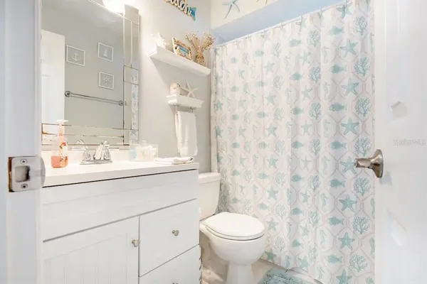 a bathroom with a sink a toilet and shower curtain