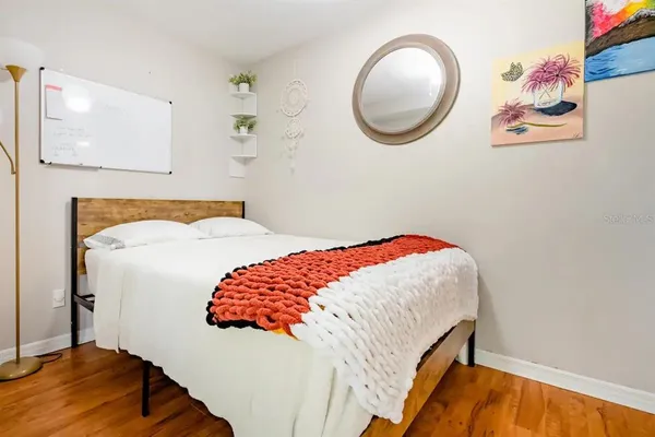 a bedroom with a bed and a painting on the wall