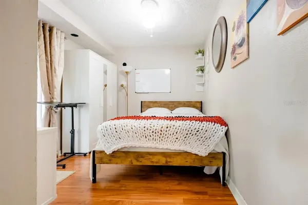 a bedroom with a bed and wooden floor