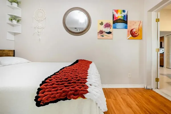 a bedroom with a bed and a painting on the wall