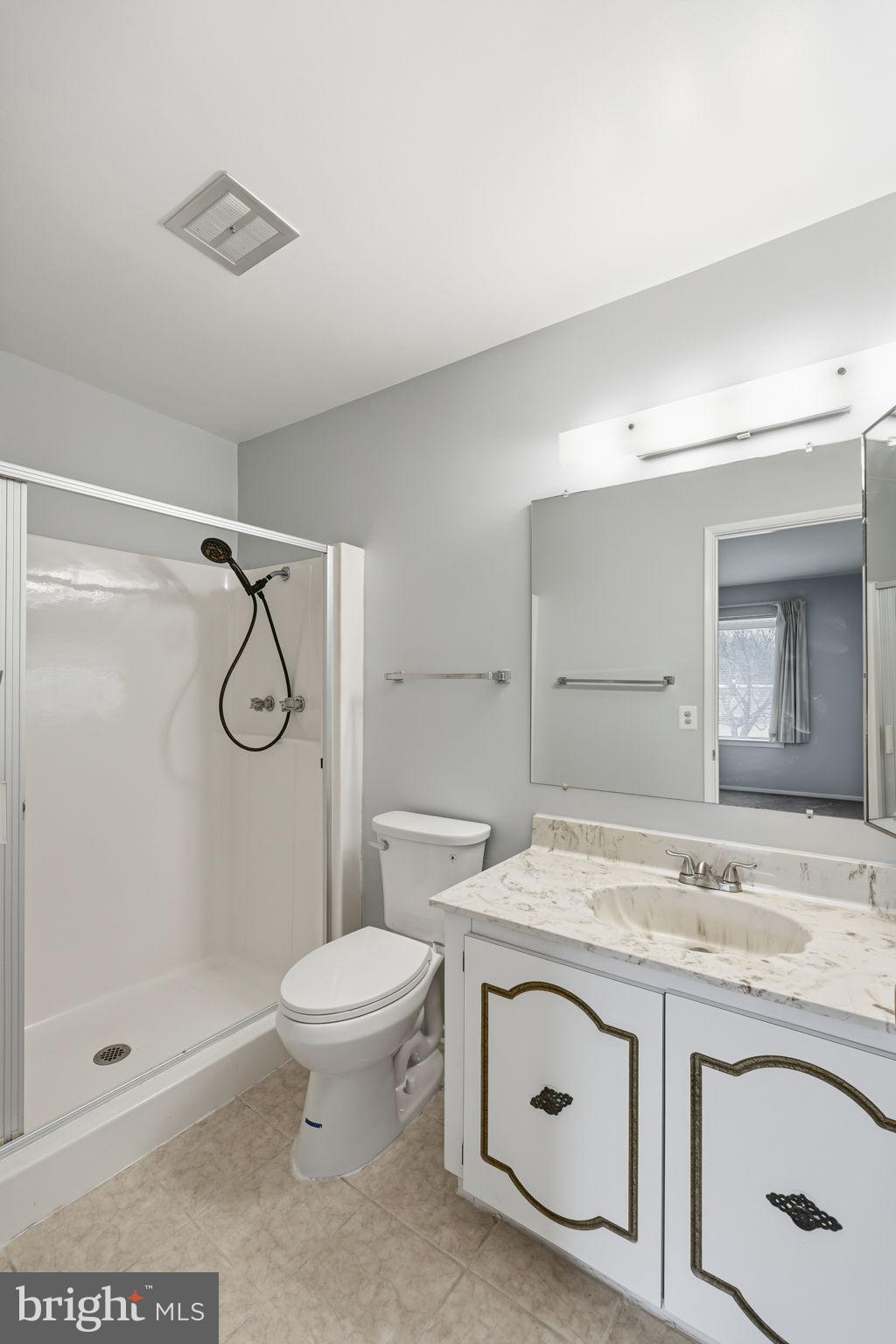 3103 Beckenham Court, Unit 252D Silver Spring, MD 20906 - Photo 30 of 32 a bathroom with a granite countertop sink a toilet and shower