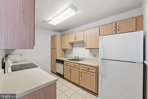 a kitchen with a sink a refrigerator and cabinets