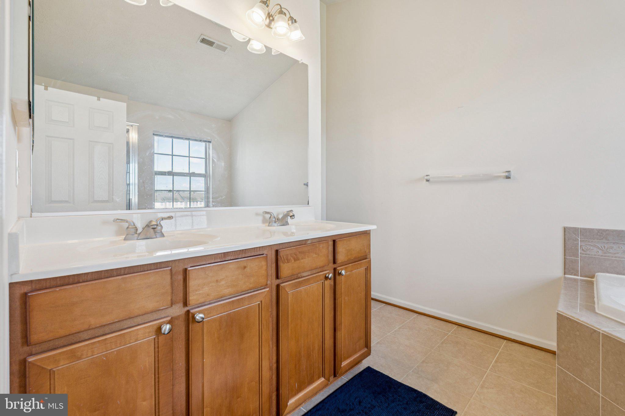 9740 Biggs Road Middle River, MD 21220 - Photo 22 of 37 a bathroom with a sink a mirror and wooden floor