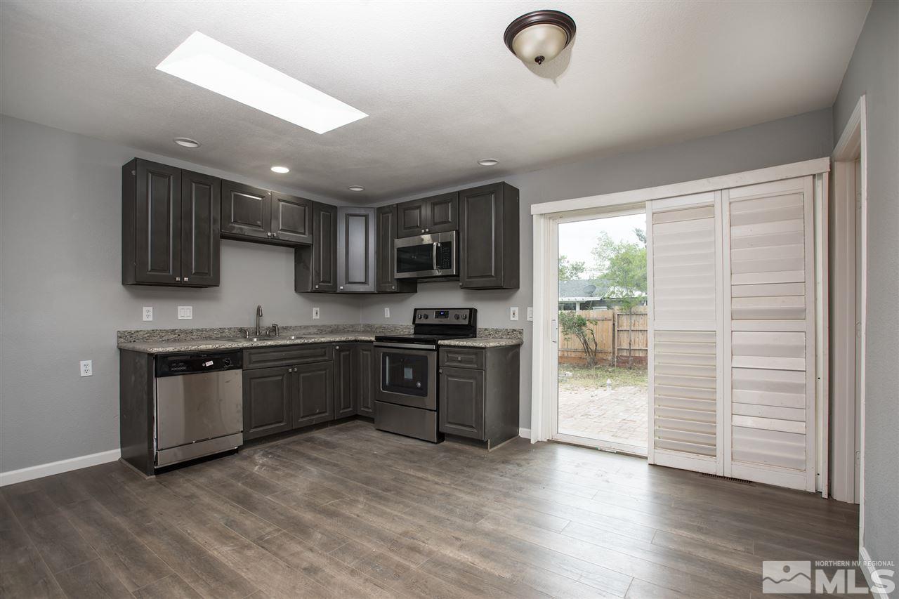600 Akard Circle Reno, NV 89503 - Photo 10 of 25 a kitchen with granite countertop a stove top oven a sink dishwasher a refrigerator and a microwave oven with wooden floor