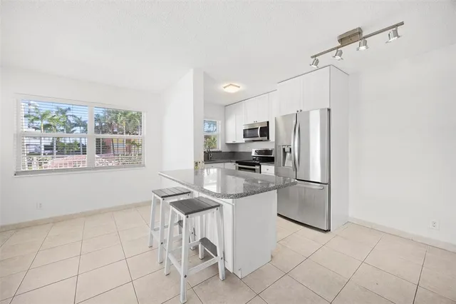 a kitchen with stainless steel appliances a refrigerator sink and microwave