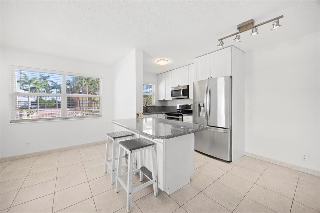 a kitchen with stainless steel appliances a refrigerator sink and microwave