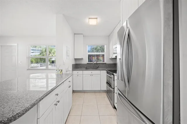 a kitchen with granite countertop a sink stove and refrigerator