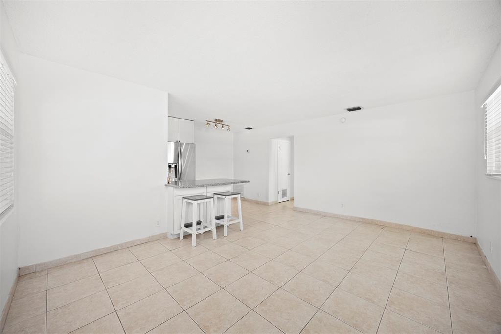 2131 North Ocean Boulevard, Unit 17 Fort Lauderdale, FL 33305 - Photo 8 of 27 a view of a kitchen with table and chairs