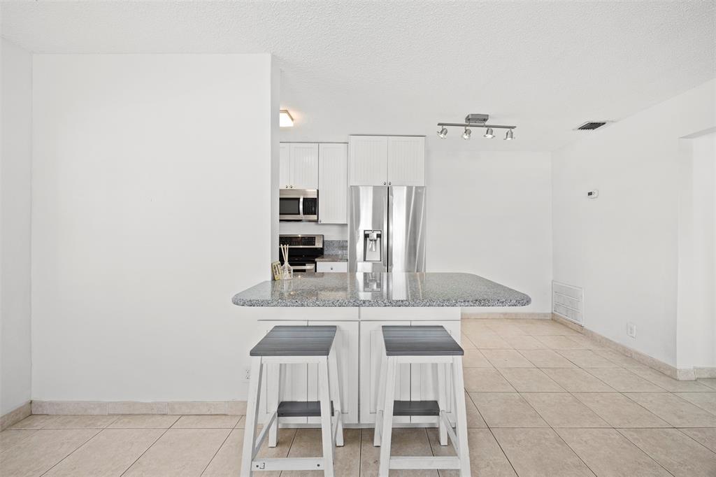 2131 North Ocean Boulevard, Unit 17 Fort Lauderdale, FL 33305 - Photo 10 of 27 a kitchen with a table and chairs