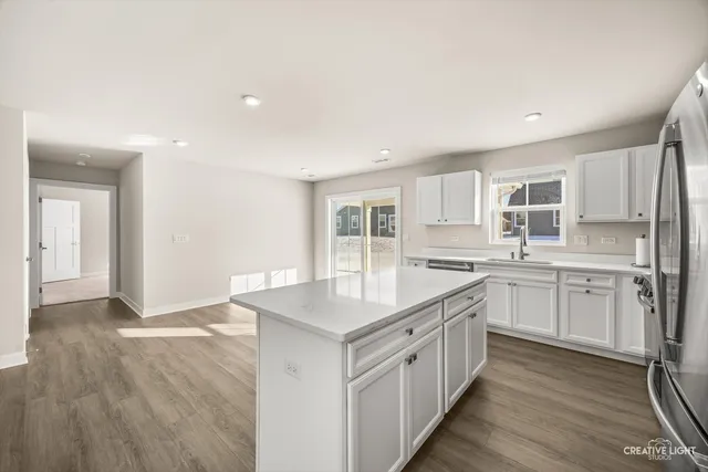 a kitchen with granite countertop white cabinets and white appliances