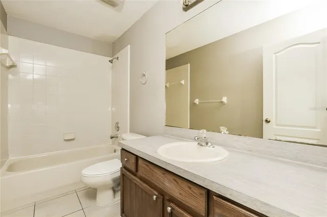 a bathroom with a granite countertop sink a toilet and shower