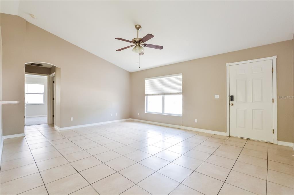 713 Willow Run Street Minneola, FL 34715 - Photo 2 of 16 a view of an empty room with window and chandelier fan