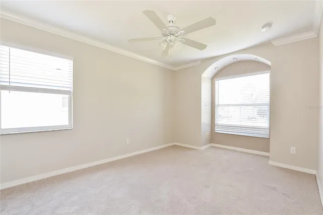 an empty room with a window and a fan