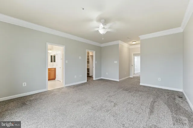 a view of an empty room with a chandelier fan