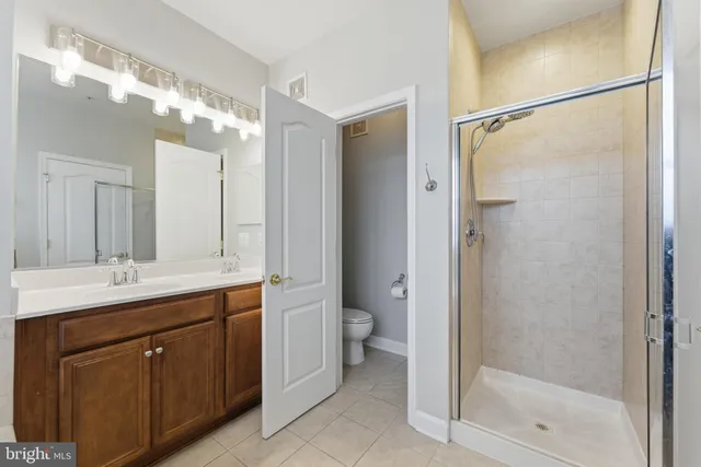 a bathroom with a double vanity sink toilet and shower