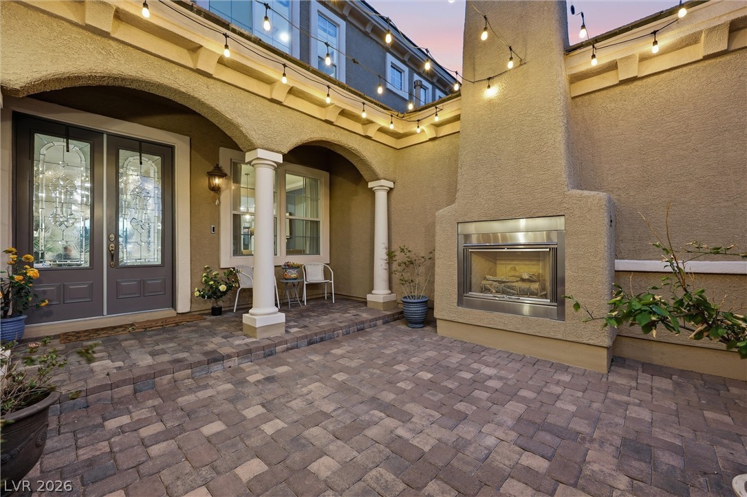 This inviting patio entry features an outdoor fireplace, perfect for tranquil evenings.