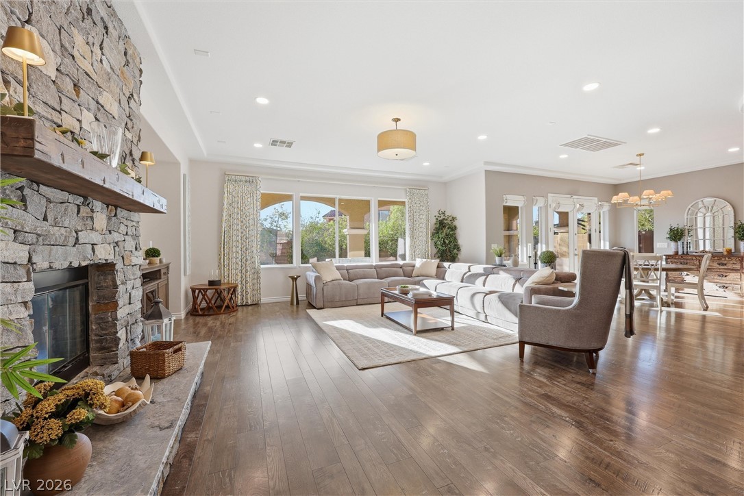 2737 Tarbert Street Henderson, NV 89044 - Photo 16 of 60 This expansive living space features a captivating stone fireplace, abundant natural light, and rich hardwood flooring.