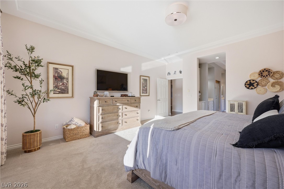 2737 Tarbert Street Henderson, NV 89044 - Photo 31 of 60 This peaceful bedroom offers plush carpeting and a view into an adjoining primary bathroom.
