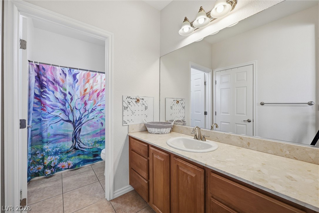 2737 Tarbert Street Henderson, NV 89044 - Photo 36 of 60 This bathroom features a single vanity with ample counter space, a large mirror, and tiled flooring.