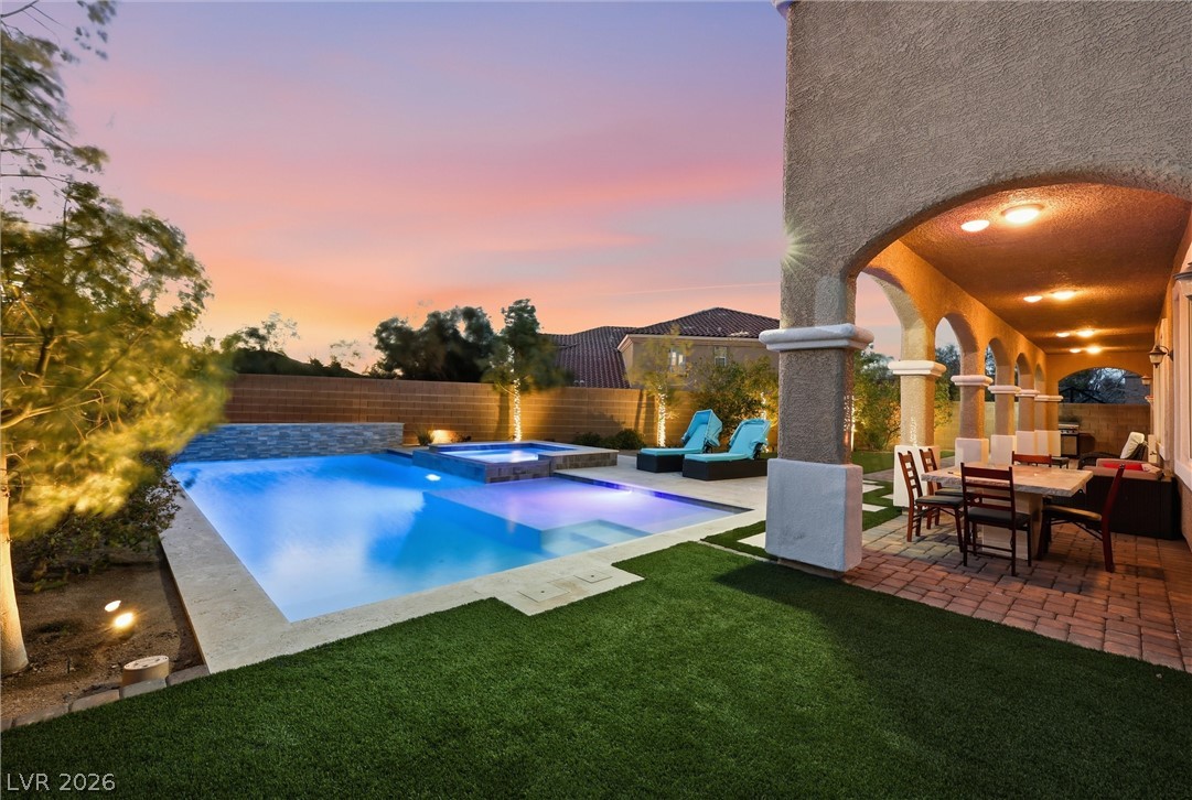 2737 Tarbert Street Henderson, NV 89044 - Photo 4 of 60 An inviting outdoor living space features a sparkling pool and a covered patio, perfect for evening relaxation.