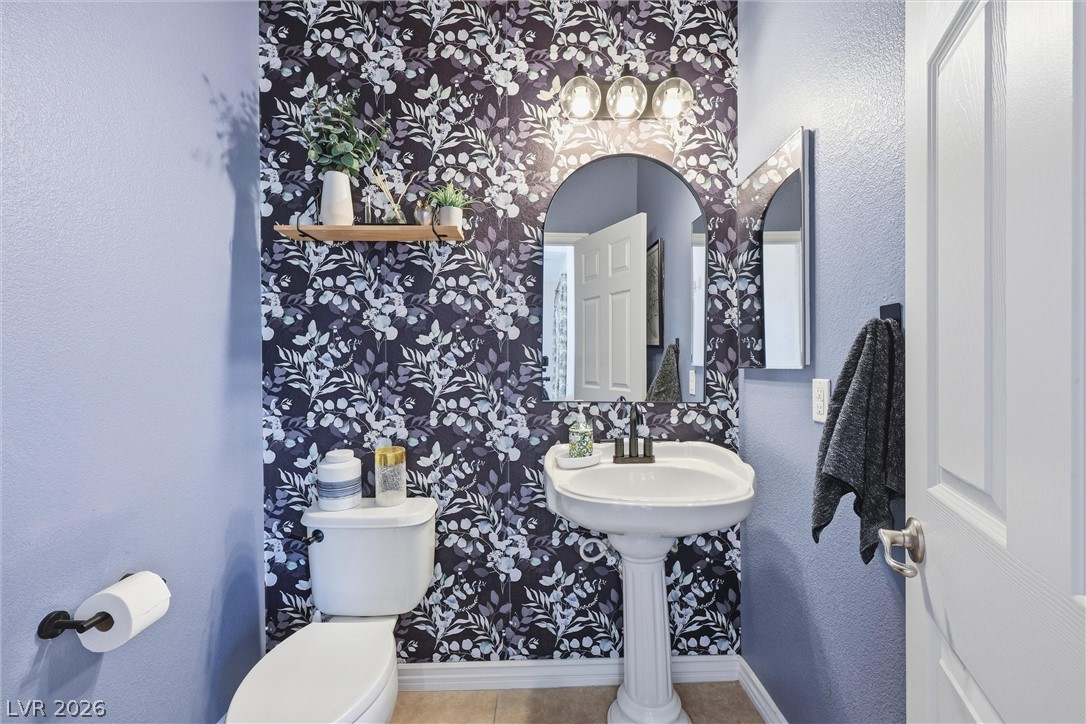2737 Tarbert Street Henderson, NV 89044 - Photo 42 of 60 This bathroom features a contemporary pedestal sink and stylish patterned wallpaper.