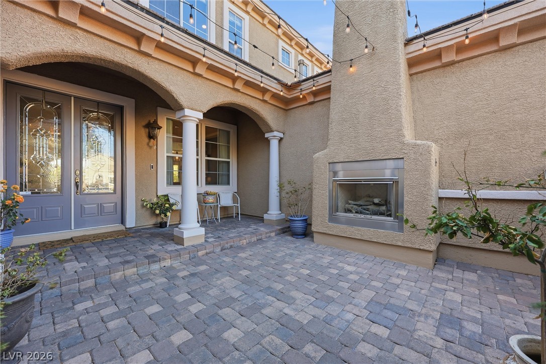 2737 Tarbert Street Henderson, NV 89044 - Photo 50 of 60 This inviting entryway features a charming outdoor fireplace and durable paver flooring.