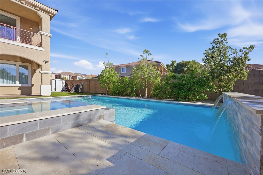 2737 Tarbert Street Henderson, NV 89044 - Photo 56 of 60 An inviting backyard oasis features a glistening pool with cascading water, perfect for relaxation.