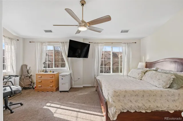 a bedroom with a bed a flat screen tv and a large window