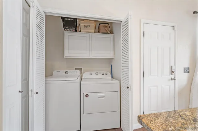 a view of washer and dryer with kitchen in the background