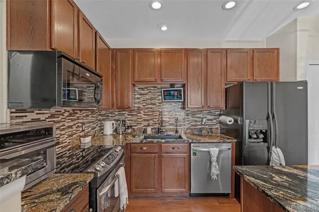 a kitchen with stainless steel appliances a stove a sink dishwasher a refrigerator and a microwave