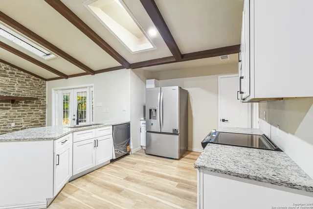 a kitchen with stainless steel appliances granite countertop a sink stove and refrigerator