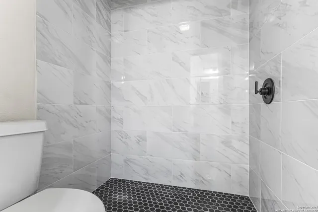 a bathroom with a toilet and a shower