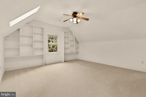 a view of an empty room with wooden floor and windows