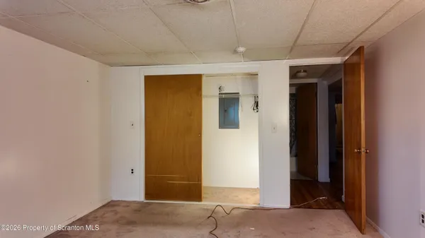 a view of a hallway with wooden floor and closet