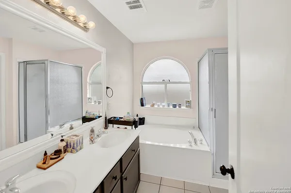 a bathroom with a tub sink and mirror