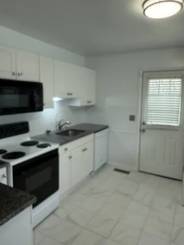 a kitchen with a sink stove and microwave
