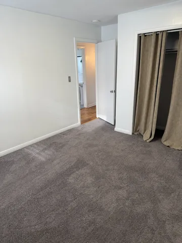 an empty room with closet and mirror