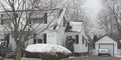 a view of a brick house with a large tree