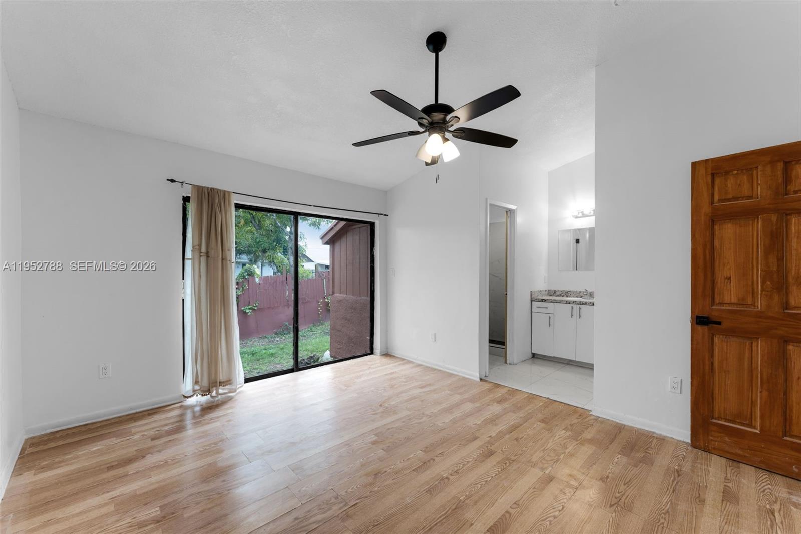 13202 Southwest 276th Terrace Homestead, FL 33032 - Photo 7 of 19 a view of empty room with wooden floor and ceiling fan