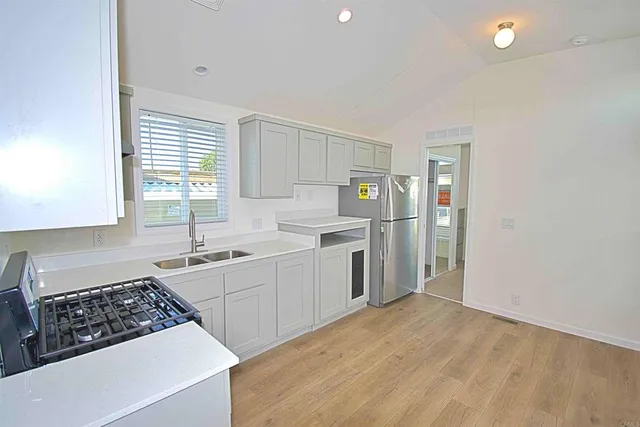 a kitchen with a sink a stove a refrigerator and cabinets