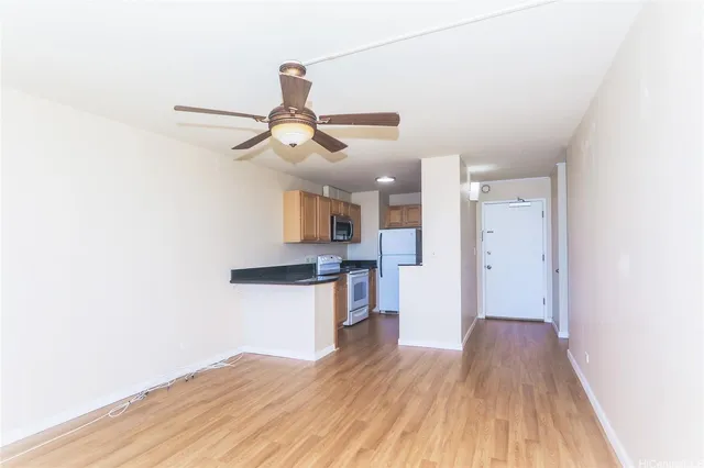 a view of a kitchen with a wooden floor and a ceiling fan
