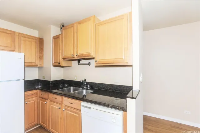 a kitchen with granite countertop white cabinets and white appliances