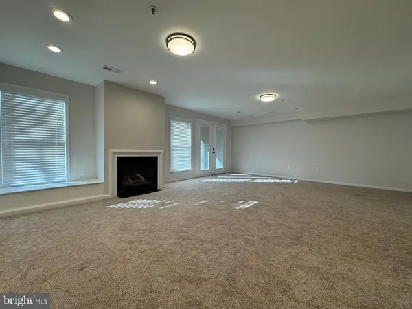 an empty room with a fireplace and fan