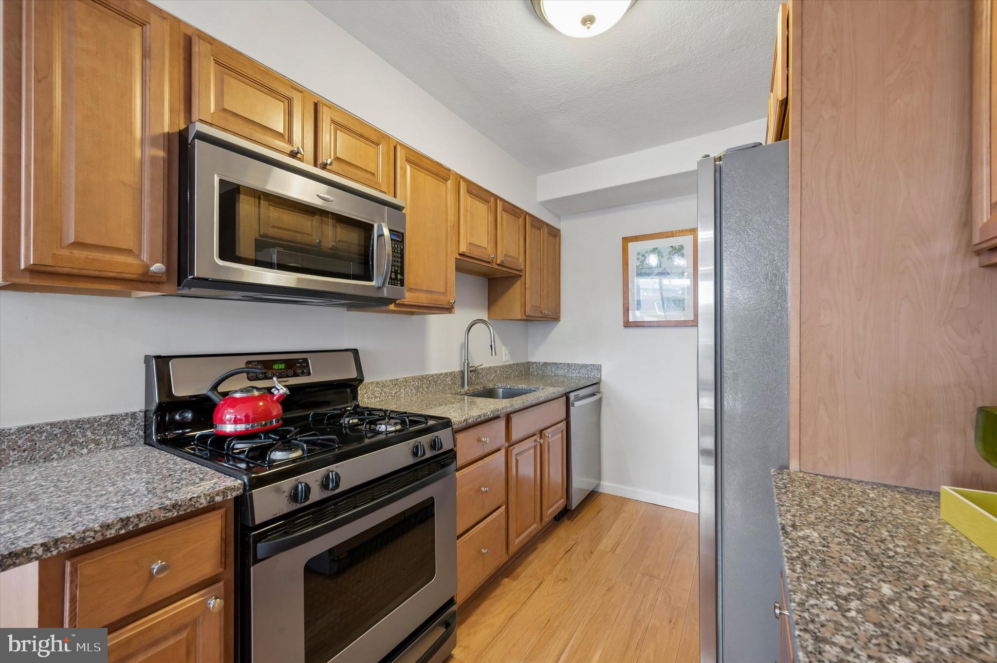 604 South Washington Square, Unit 309 Philadelphia, PA 19106 - Photo 7 of 28 a kitchen with stainless steel appliances granite countertop a stove microwave and cabinets