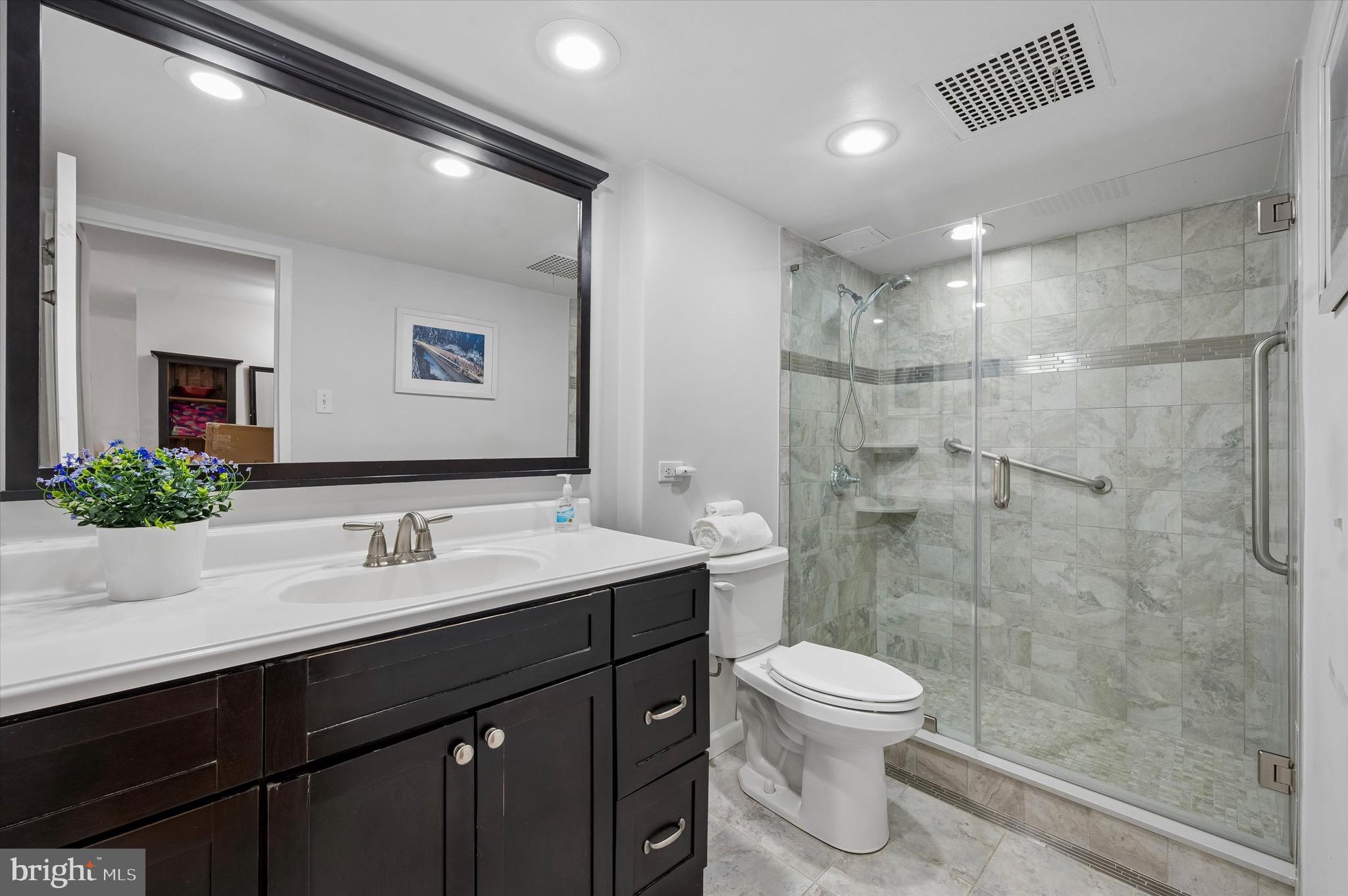 604 South Washington Square, Unit 309 Philadelphia, PA 19106 - Photo 9 of 28 a bathroom with a toilet sink a shower and a mirror