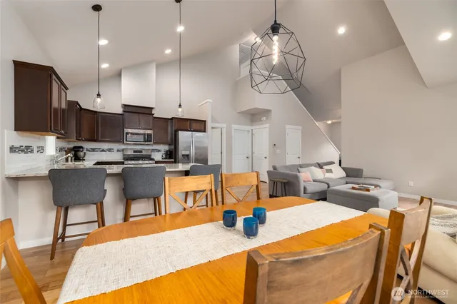 a kitchen with stainless steel appliances kitchen island granite countertop a sink a stove and chairs